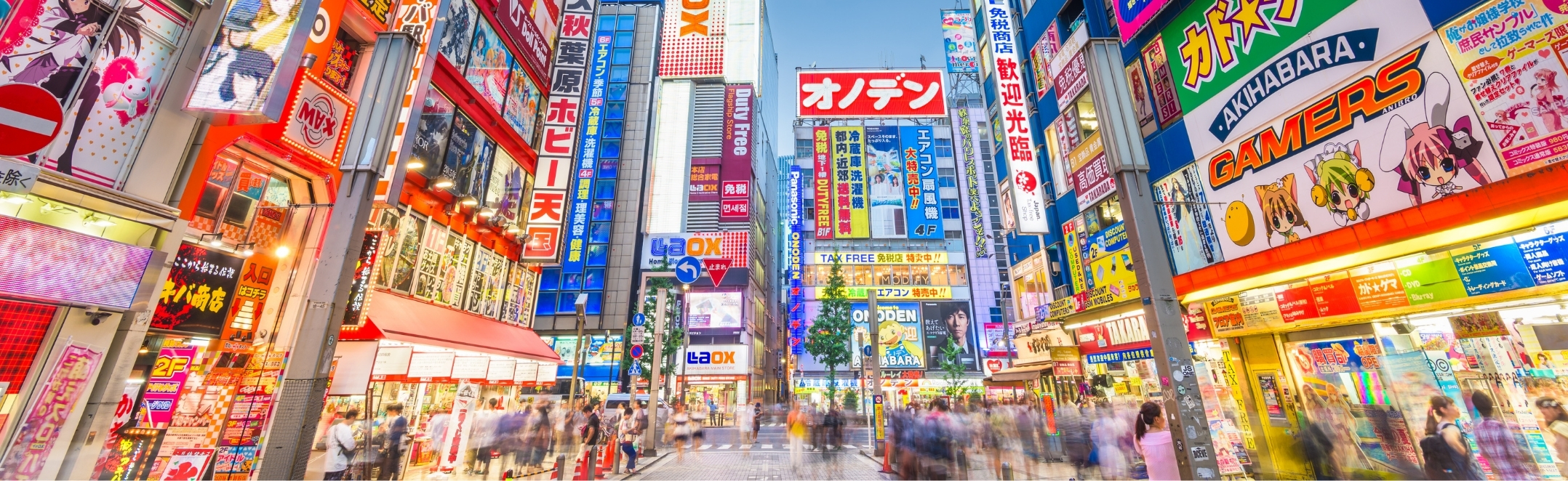 Anime billboards and neon signs tower over Akihabara's crowded streets, capturing Tokyo's electric, sensory-rich energy.