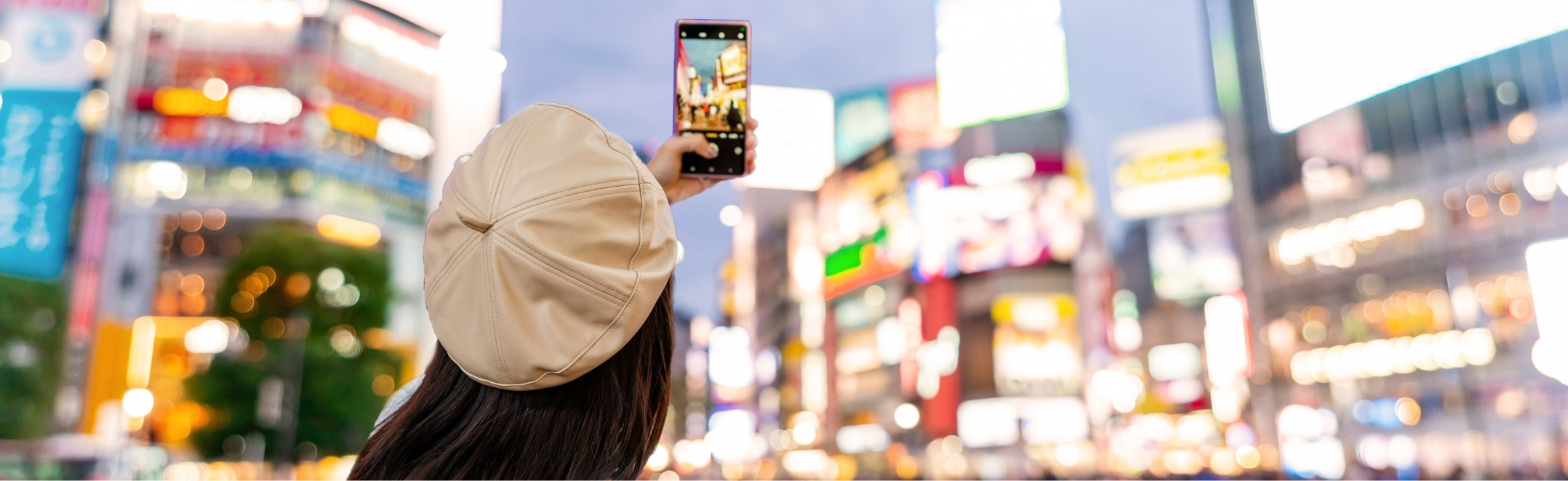 A tourist capturing the heart of Tokyo at the Shibuya crossing in Japan.