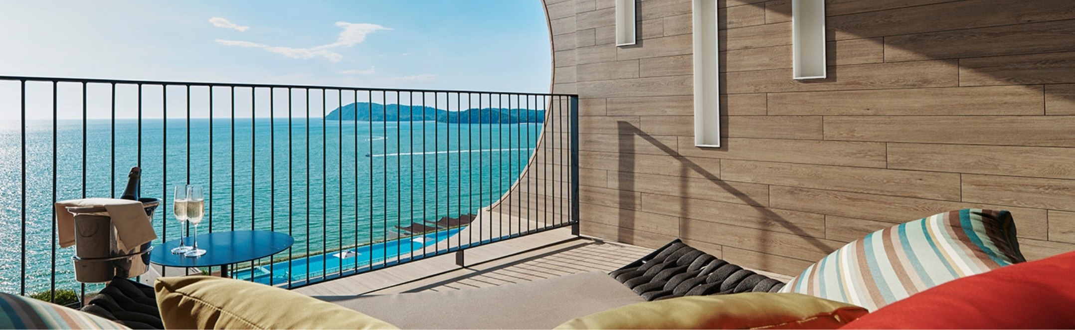 Parasailers glide over turquoise waters as seen from the Deluxe Ocean View Suite at PARKROYAL Langkawi Resort, Malaysia.